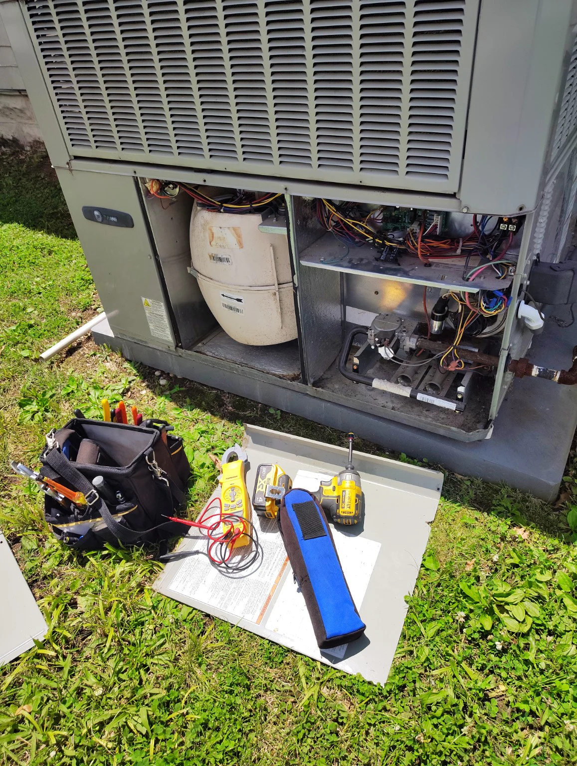 Packaged HVAC equipment opened with field tools ready for testing